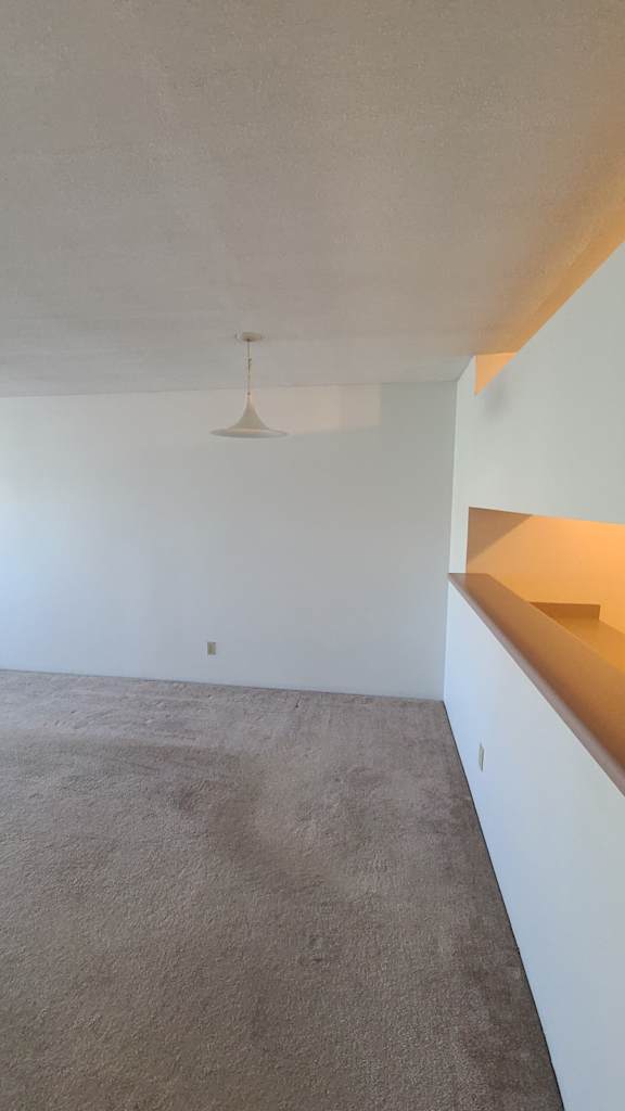 a room with white walls and a beige carpet
