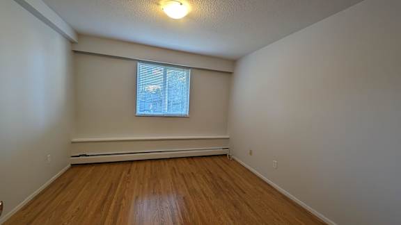 A room with wooden floors and a window.