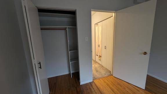 A hallway with a white door and a white wall.