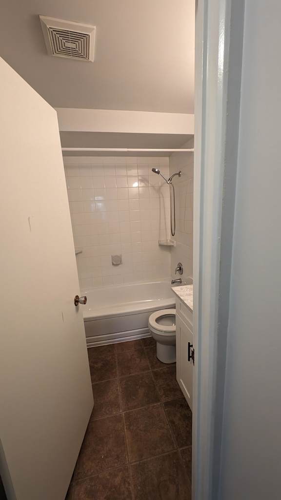 A bathroom with a toilet and a shower.