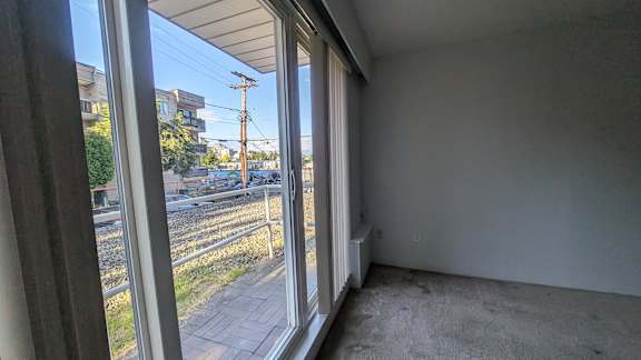 A room with a view of a street through large windows.