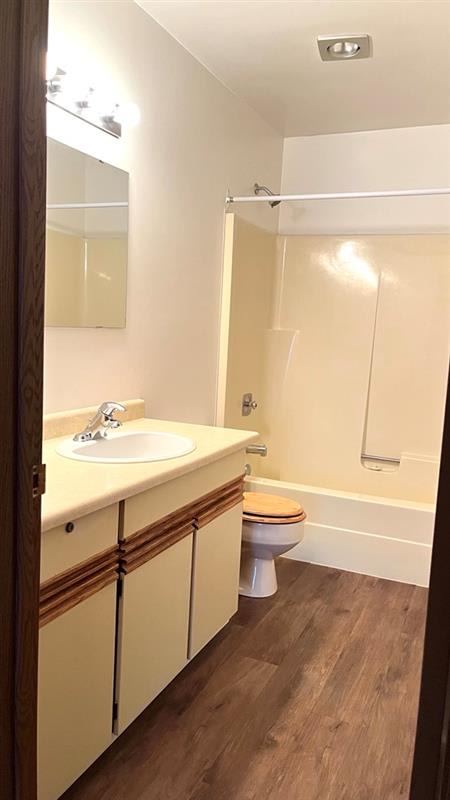 A bathroom with a toilet, sink, and mirror.