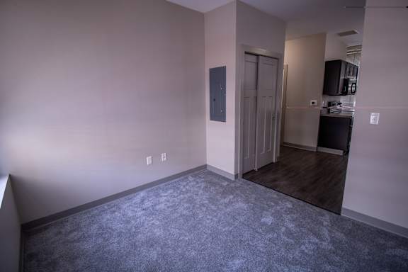 A room with a carpeted floor and a door leading to another room.