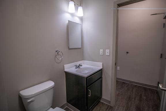 A bathroom with a toilet, sink, and light fixture.