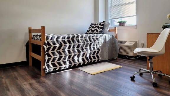 a bedroom with a bed and a chair and a window
