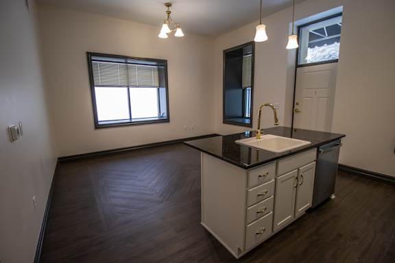A kitchen with a sink, cabinets, and a window.