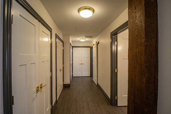 A hallway with white doors and a light on the ceiling.