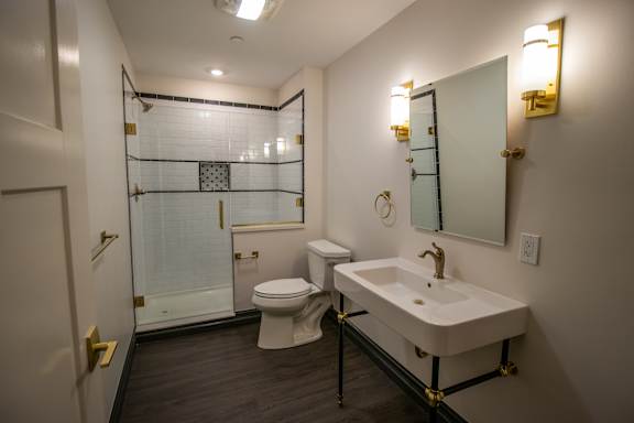 A bathroom with a toilet, sink, and shower.