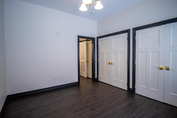 A room with a white wall and a brown door.