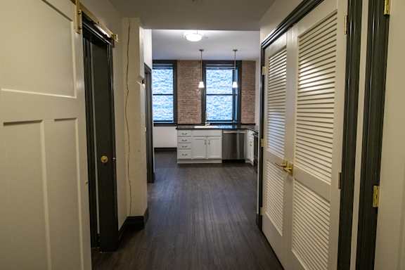 A long hallway with a kitchen at the end.