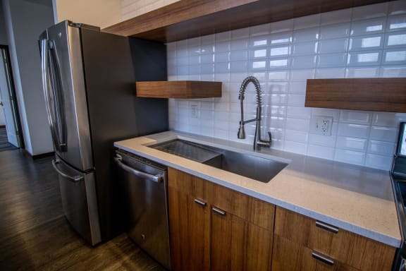 a kitchen with a sink and a stainless steel refrigerator