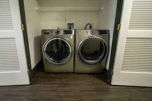 Two front loading washing machines in a small laundry room.