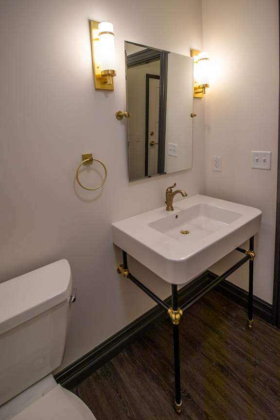 A white sink with gold fixtures in a bathroom.