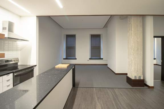 an empty room with a kitchen and a window