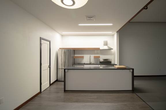 a kitchen with a counter and a refrigerator and a door