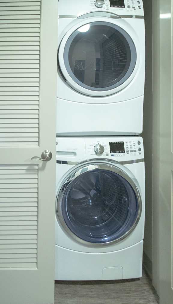 A white washing machine is in front of a white door.