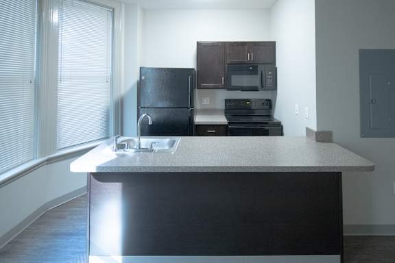 A kitchen with a black refrigerator and stove.