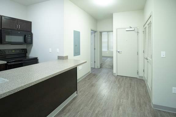 A kitchen with dark brown cabinets and a counter top.