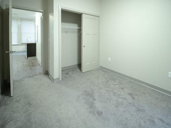 A room with a carpeted floor and two open doors.