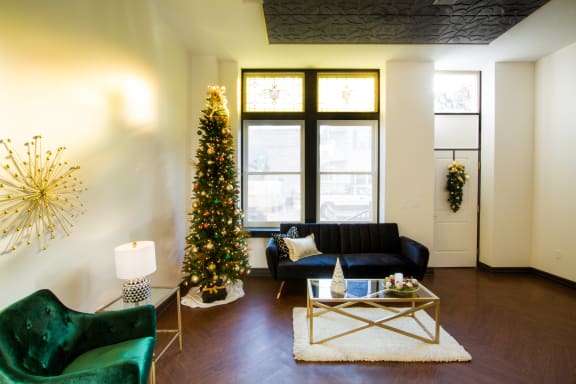 a living room with a christmas tree and a black couch