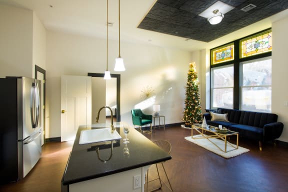 a kitchen and living room with a christmas tree in the corner
