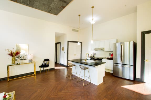 a kitchen with a large island and a stainless steel refrigerator