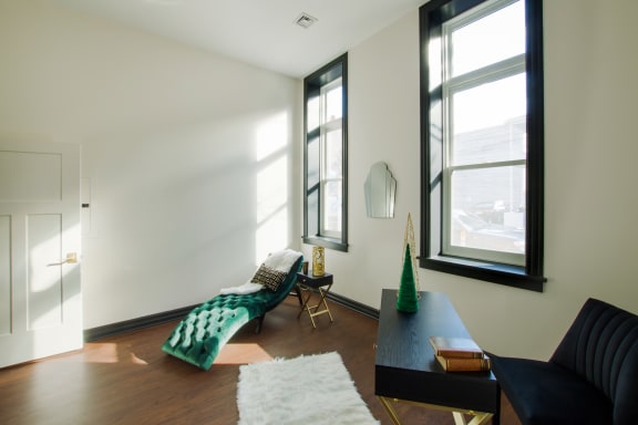 a living room with a couch and a table and two windows