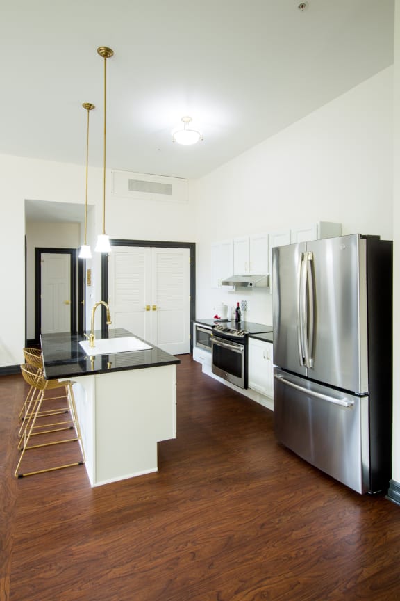 a kitchen with white cabinets and a stainless steel refrigerator