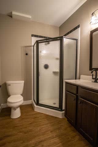 a bathroom with a shower and a toilet and a sink