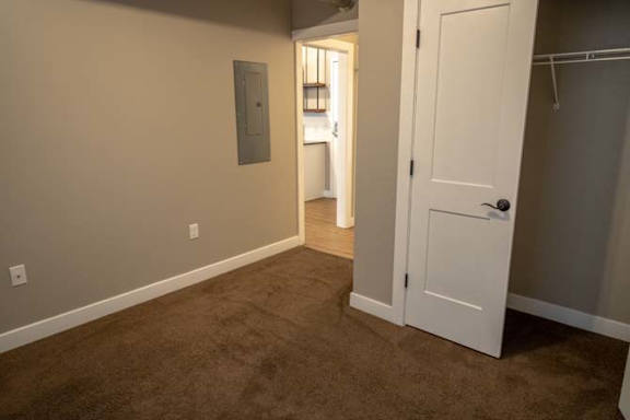an empty room with a white door and a closet