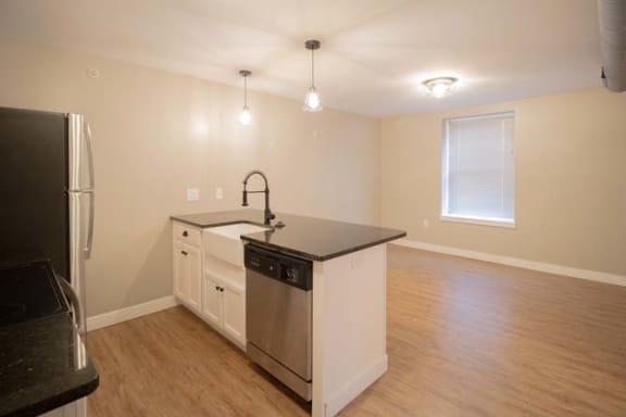 an empty kitchen with a sink and a refrigerator