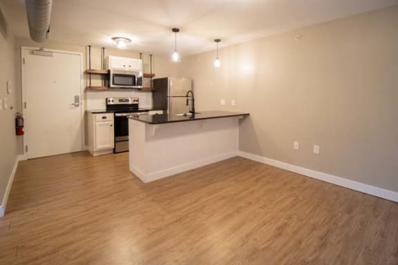 an empty living room with a kitchen and a