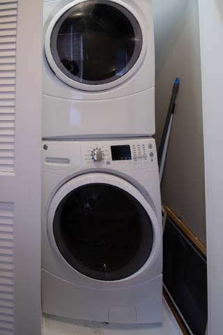 a white washer and dryer in a white closet