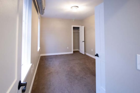 a empty living room with a door to a hallway