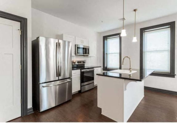 a kitchen with a stainless steel refrigerator and a sink