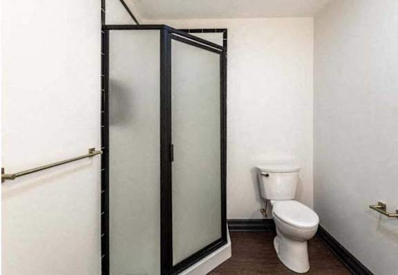 a white bathroom with a toilet and a shower