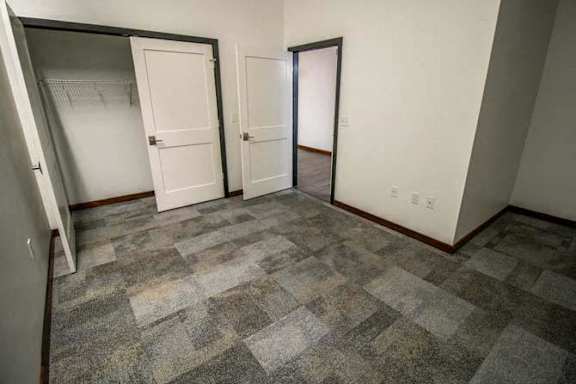 a room with a carpeted floor and two doors