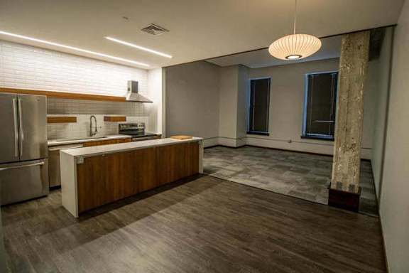 an empty kitchen with a refrigerator and a sink