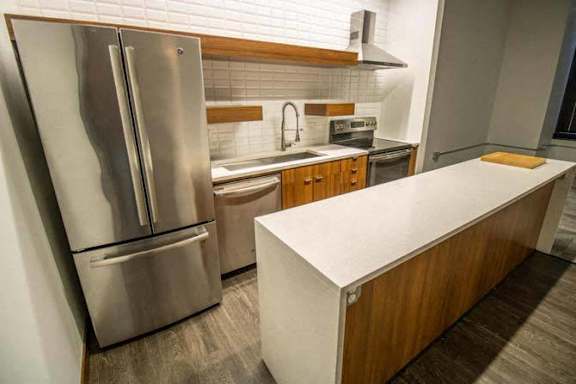 a kitchen with a stainless steel refrigerator and a white counter