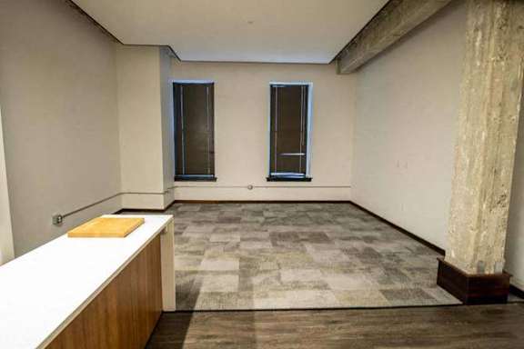 an empty room with a counter and a window