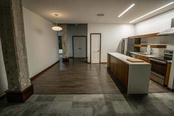an empty kitchen with a counter top and a sink