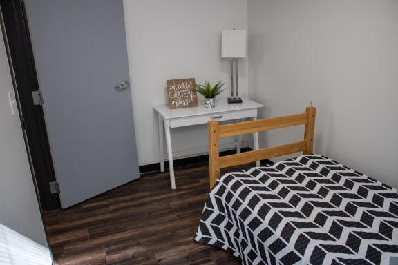 an empty bedroom with a bed and a desk