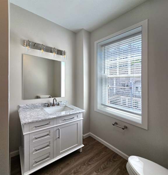 A bathroom with a marble countertop and a large mirror.