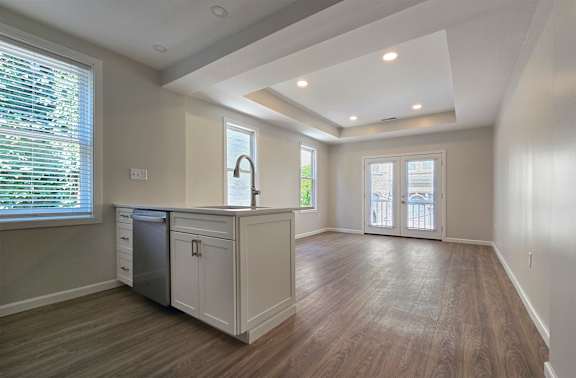 A kitchen with wooden floors and white cabinets.