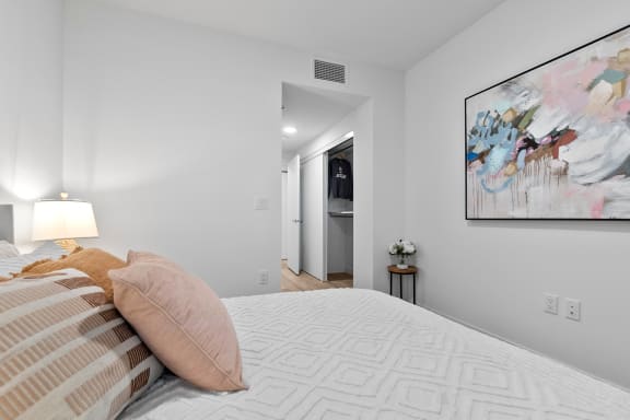 a bedroom with a large bed and a painting on the wall