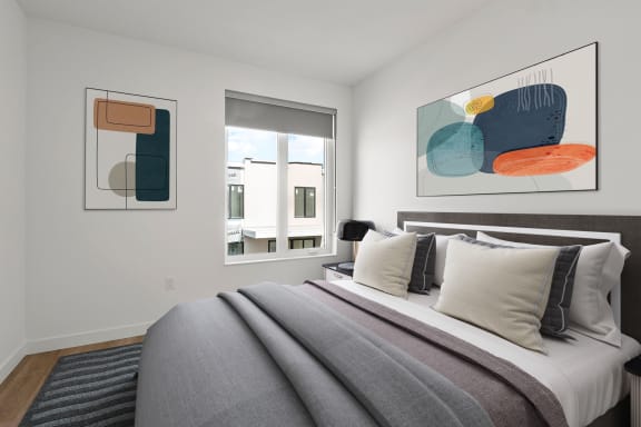 a bedroom with a large bed and two windows in a 555 waverly unit