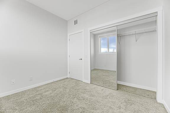 A white room with a sliding door and a mirror.