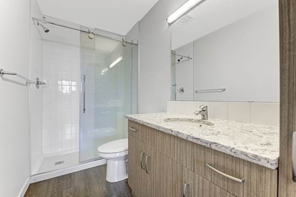 A bathroom with a marble countertop and a walk-in shower.