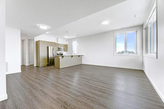A room with wooden flooring and white walls.