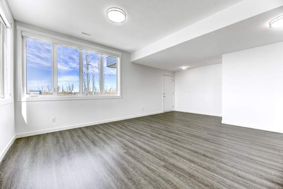 A room with a large window and wooden flooring.